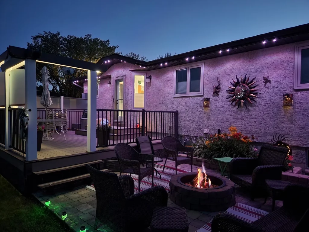 Gemstone lights illuminate a cozy outdoor space with a fire pit and seating