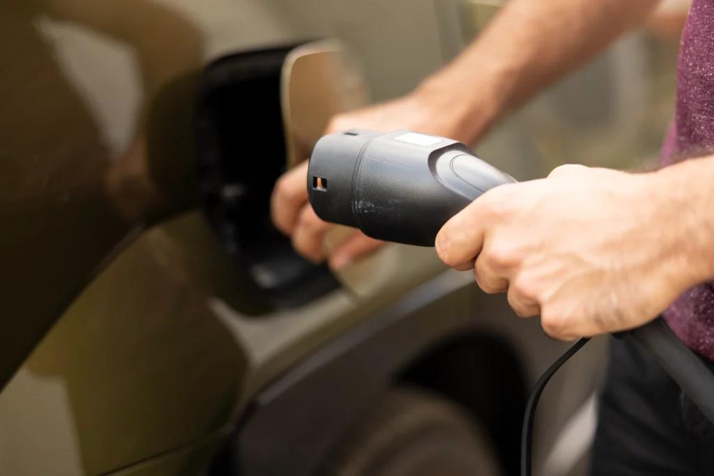 Person connecting a charging plug during ev charger installation