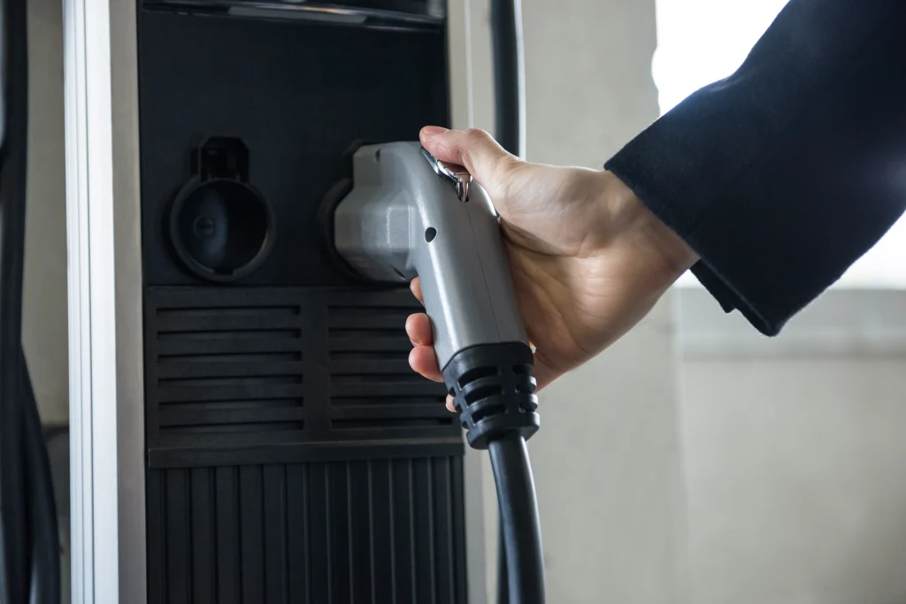 Hand connecting an ev charger installation to a charging station for electric vehicles