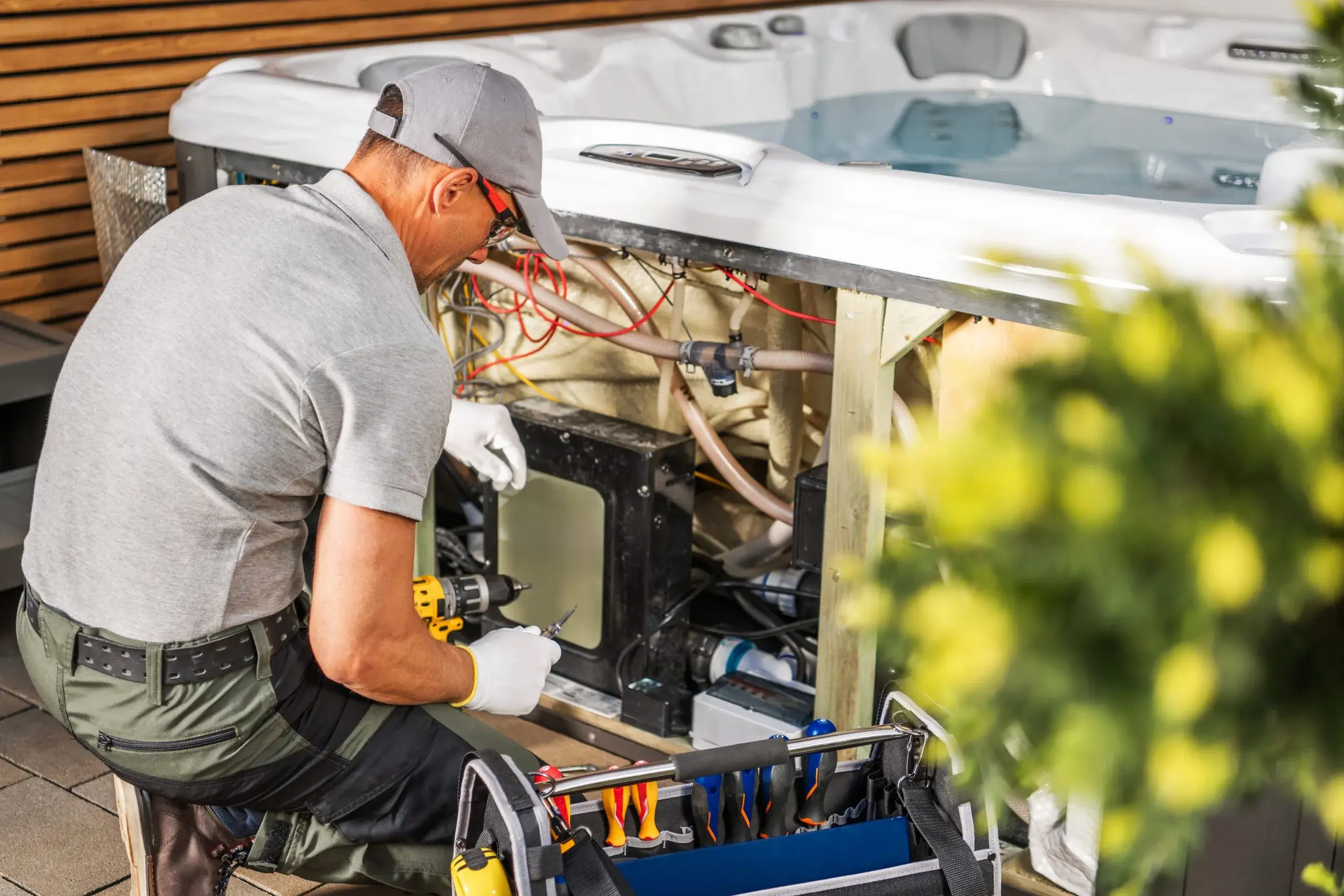 A technician repairs the internal components of a hot tub